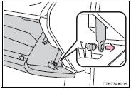 3 Push in the glove box on the vehicle’s outer side to disconnect the claws.