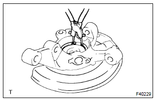 Toyota Corolla. Remove front axle hub lh hole snap ring